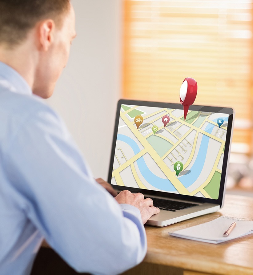 A man searching for local SEO services on his laptop in a focused work setting.