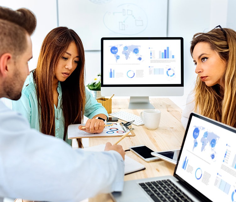 Three colleagues having a discussion in their office.